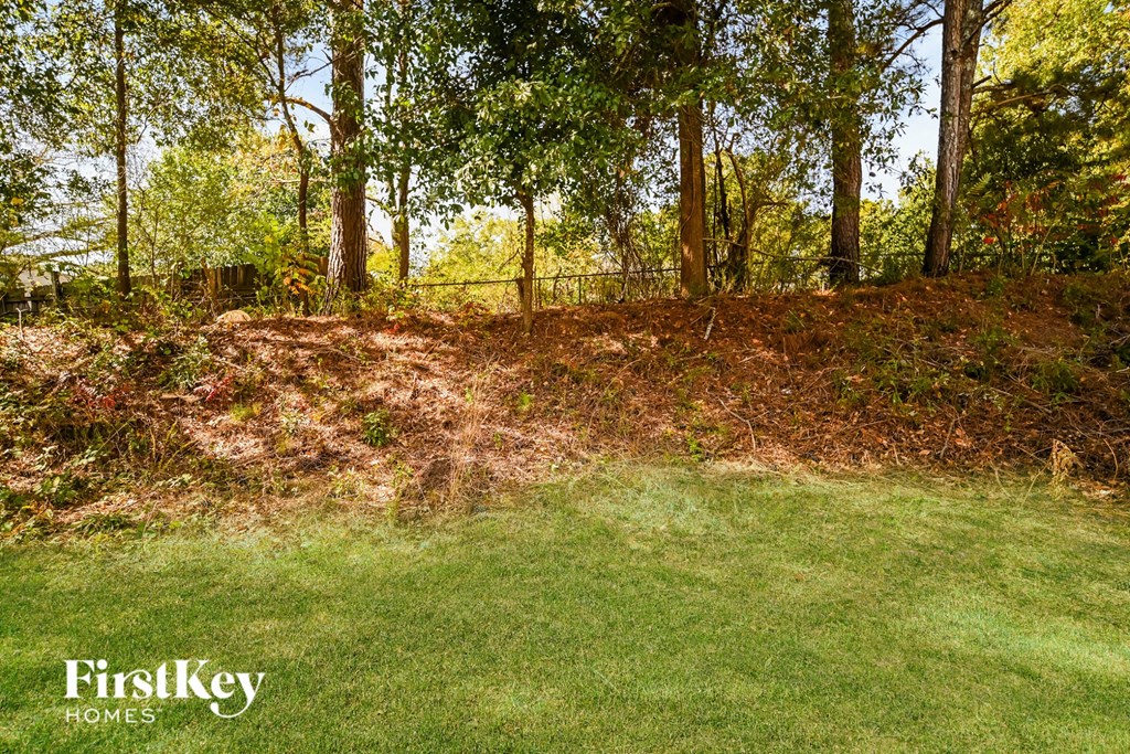 A grassy area with trees in the background and a FirstKey Homes logo.