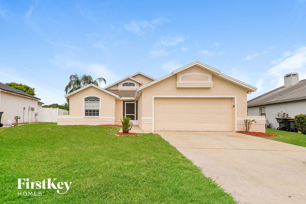 A house with a garage and a driveway is for sale.