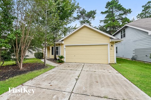 A two-car garage is attached to a house with a yellow siding.
