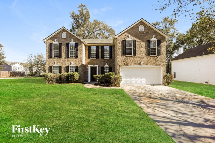 a brick house with a lawn and a white garage door