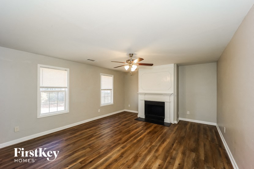a living room with a fireplace and a ceiling fan