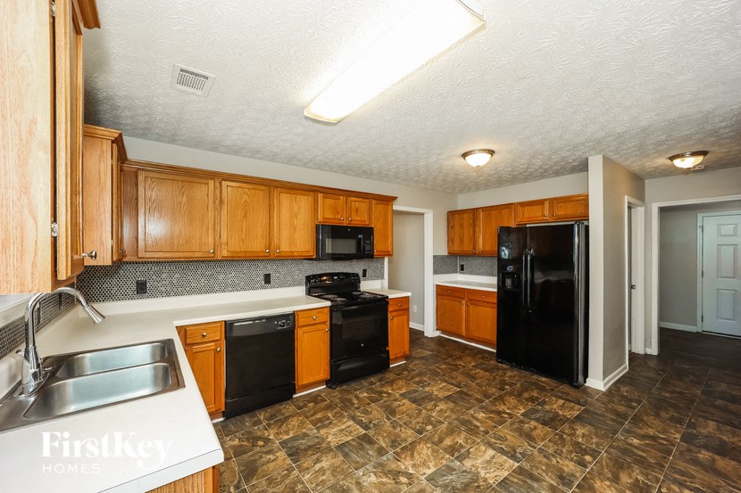 a kitchen with black appliances and wooden cabinets