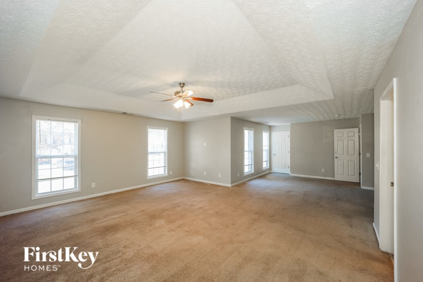 the living room of an empty house with a ceiling fan