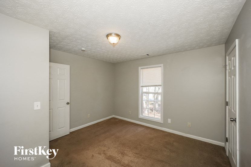 a empty living room with a white ceiling and a window