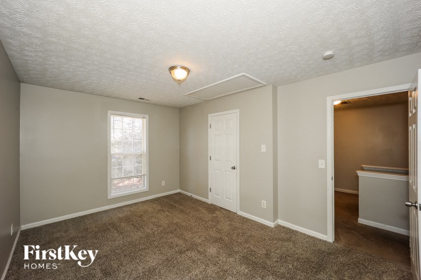 the living room of a home with a carpeted floor and a door to a