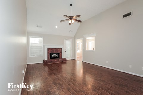 a living room with a ceiling fan and a fireplace