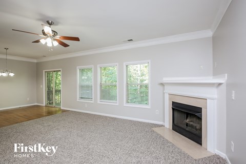 a living room with a fireplace and a ceiling fan