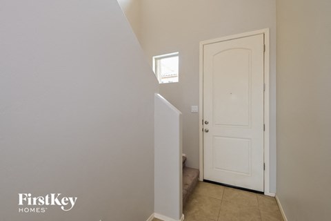 A white door is in a room with a window above it.