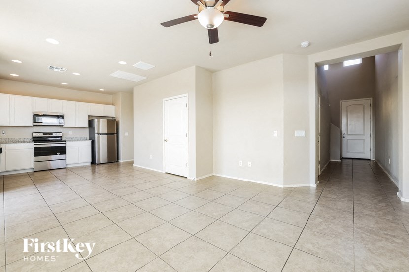 an empty kitchen and living room with a ceiling fan