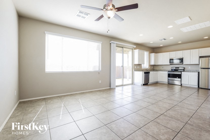 an empty kitchen and living room with a ceiling fan
