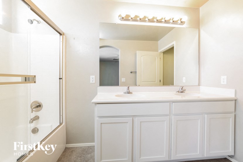 a bathroom with a sink and a shower and a mirror