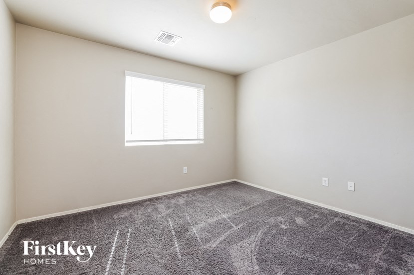 a bedroom with carpeted flooring and a window