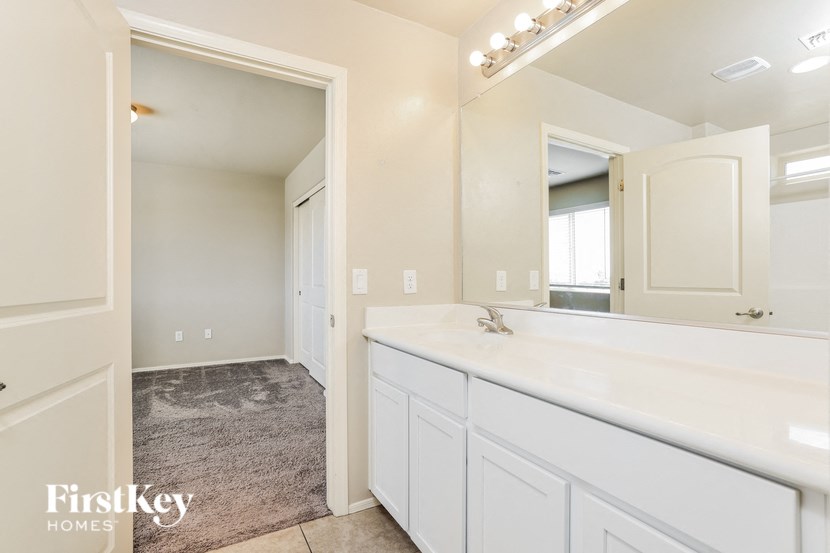 a white bathroom with a large mirror and a sink