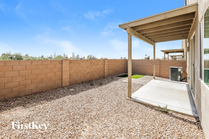 a patio with a wall and a heater on the side of a house