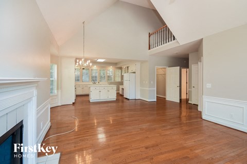 an open kitchen and living room with wood floors and a fireplace
