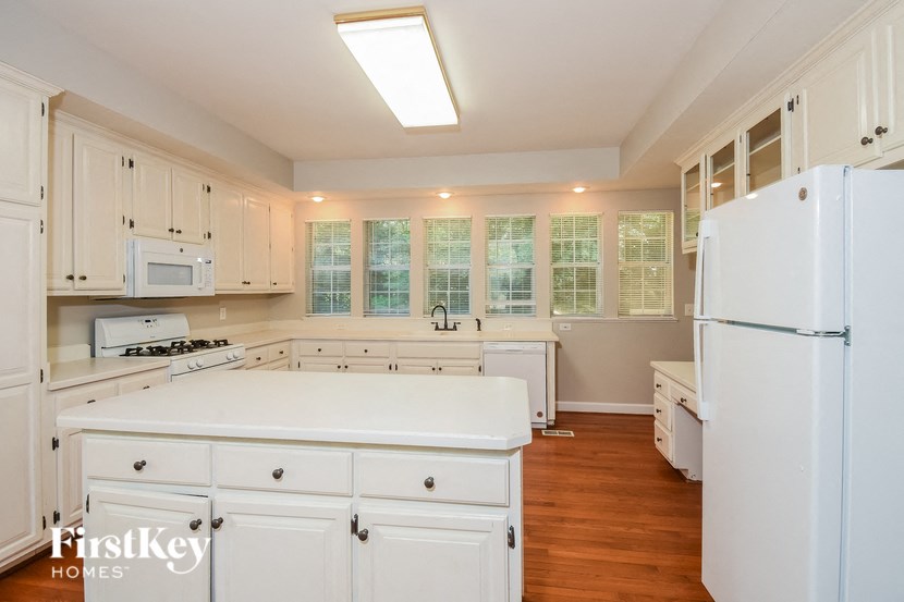 a kitchen with white cabinets and white appliances and a white counter top
