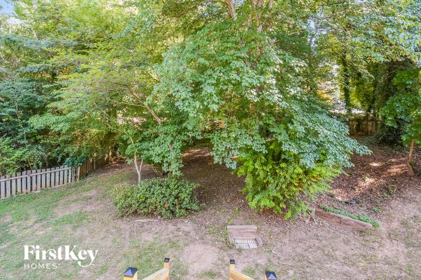 an aerial view of a backyard with trees and a bench