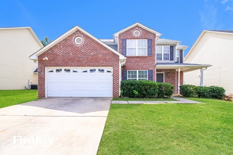 A house with a red brick exterior and a white garage door.