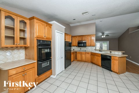 A kitchen with wooden cabinets and black appliances.