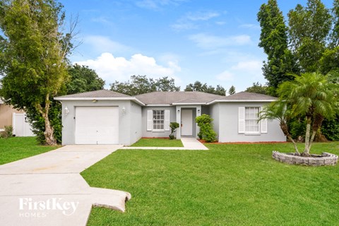 a white house with a lawn and a palm tree