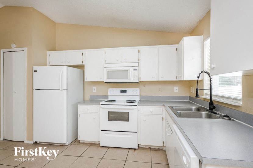 a kitchen with white appliances and white cabinets