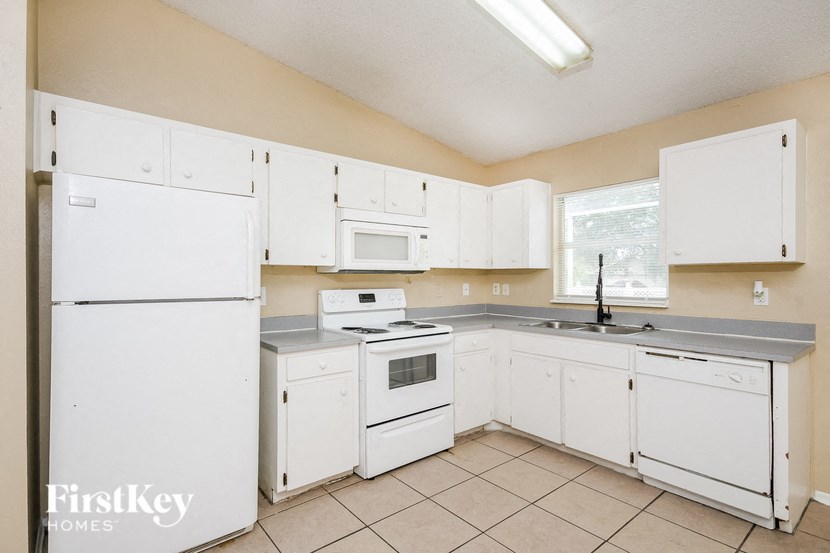 a white kitchen with white appliances and white cabinets