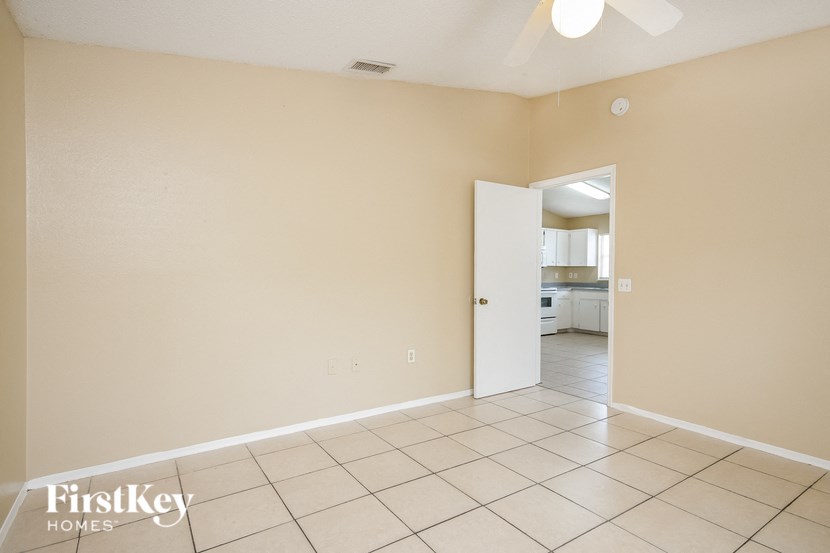 a empty living room with a door to a kitchen