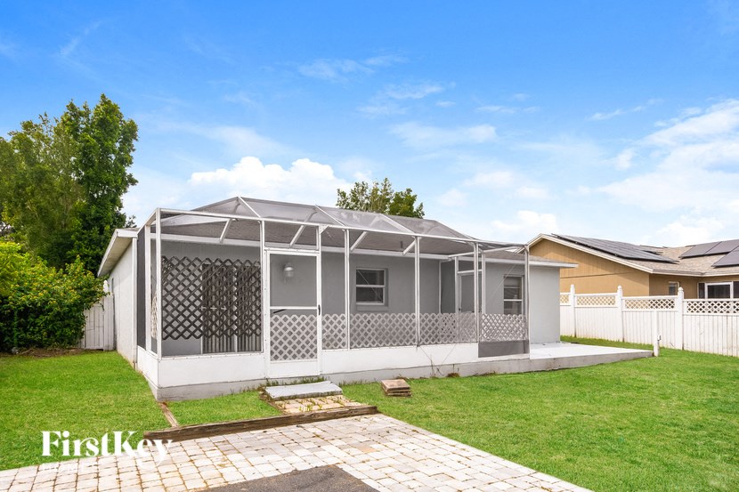 a white house with a patio and a lawn