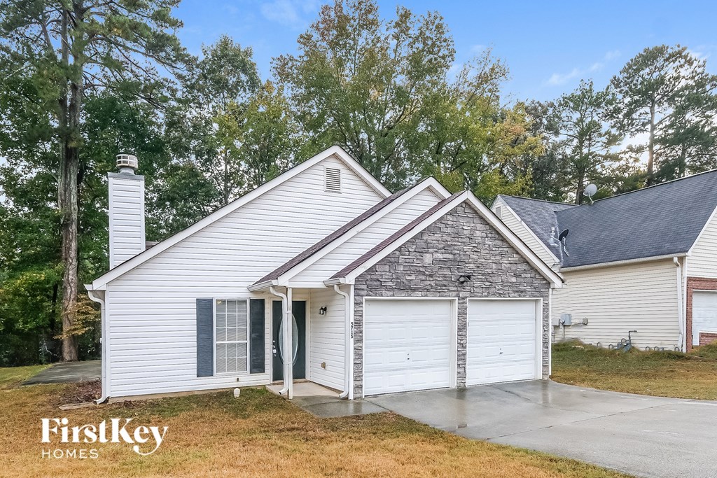A white house with a chimney and a garage door is for sale.