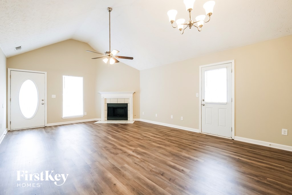 A spacious room with a fireplace and a chandelier.
