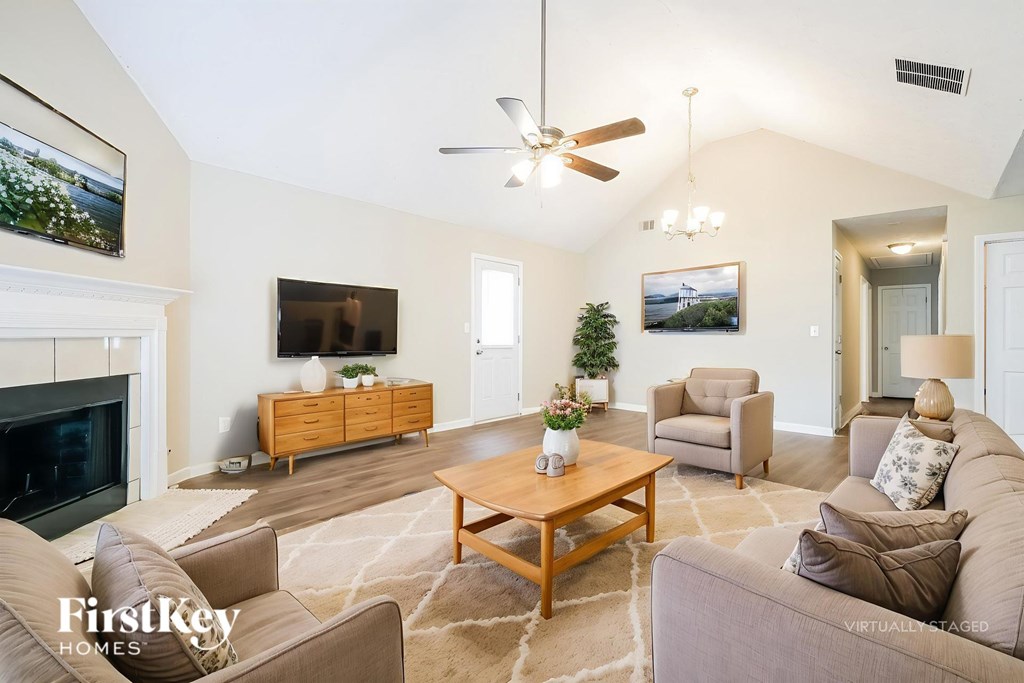 A living room with a fireplace and a television.