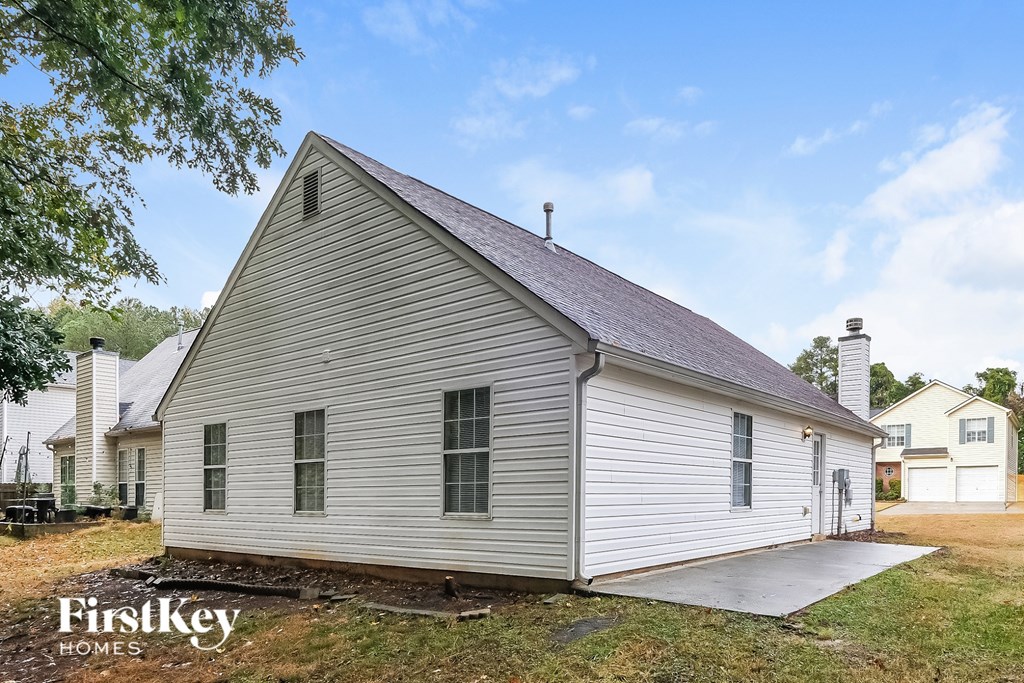 A small house with a grey roof and a white garage door.