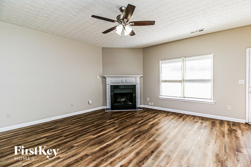A room with a fireplace and a ceiling fan.
