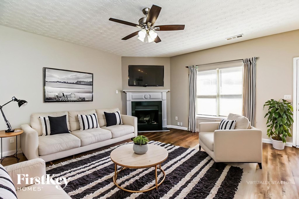 A living room with a fireplace and a television.