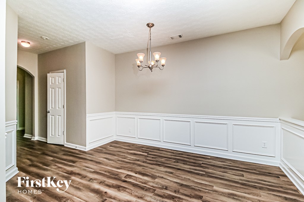 A room with wooden floors and a chandelier.