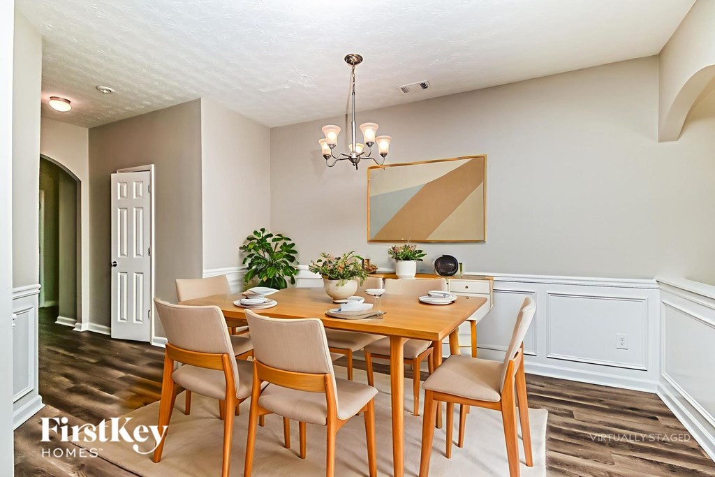 A dining room with a wooden table and chairs.