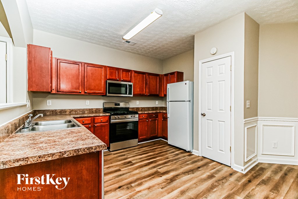 A kitchen with wooden cabinets and a granite countertop.