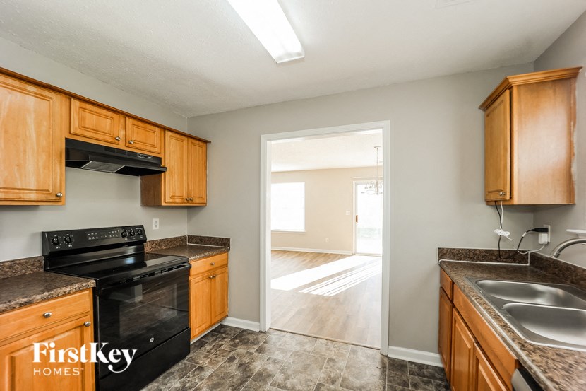 A kitchen with wooden cabinets and a black stove top oven.