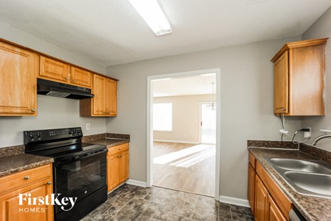 A kitchen with wooden cabinets and a black stove top oven.