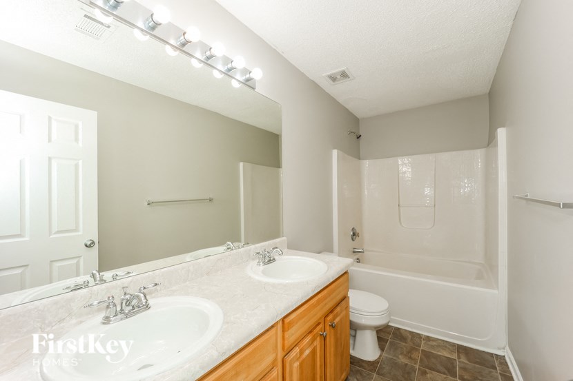 A bathroom with a marble countertop and a walk-in shower.