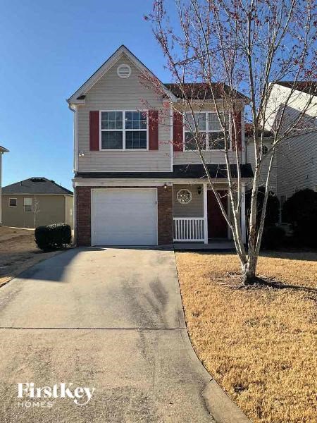 a house with a driveway and a tree in front of it
