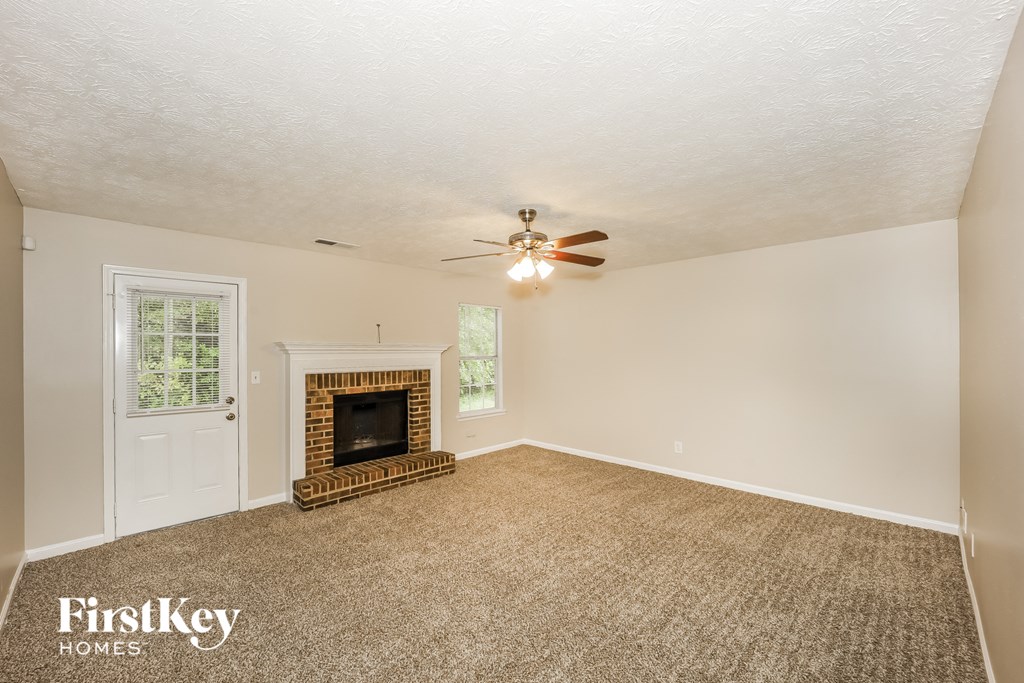 a living room with a fireplace and a ceiling fan