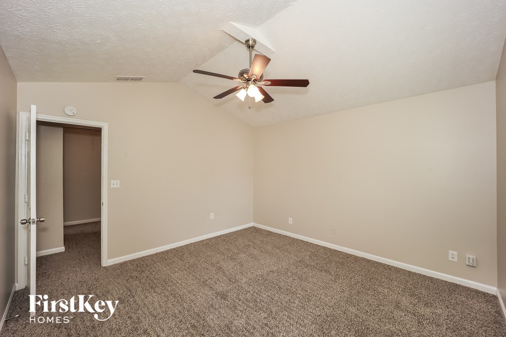 the living room of an empty house with a ceiling fan