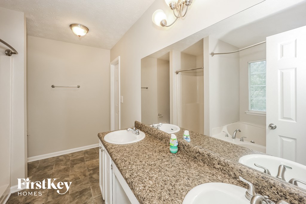a bathroom with two sinks and a tub and a mirror