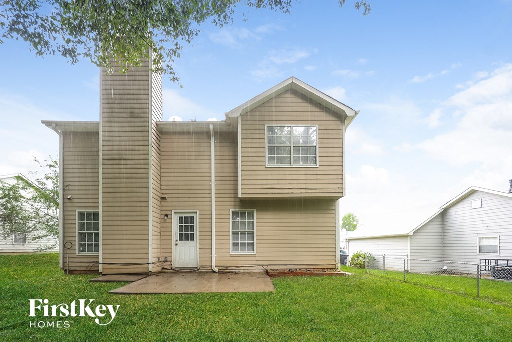 front view of a beige house with a yard and grass