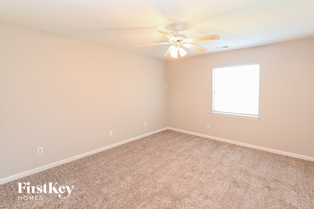 a bedroom with carpet and a ceiling fan