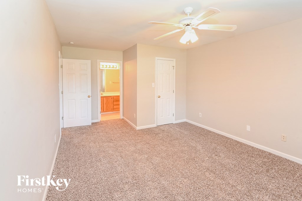 a bedroom with carpeting and a ceiling fan