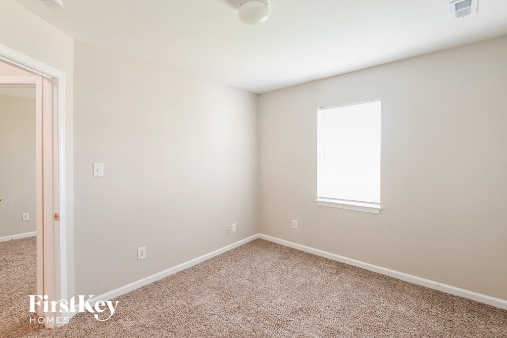 a bedroom with a carpeted floor and a window