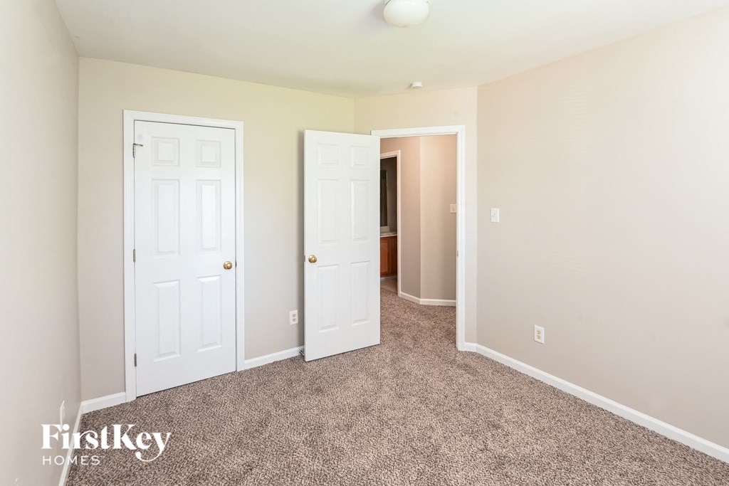 a bedroom with two white doors and a carpeted floor
