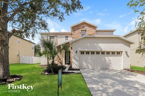 a house with a garage and a driveway and a tree